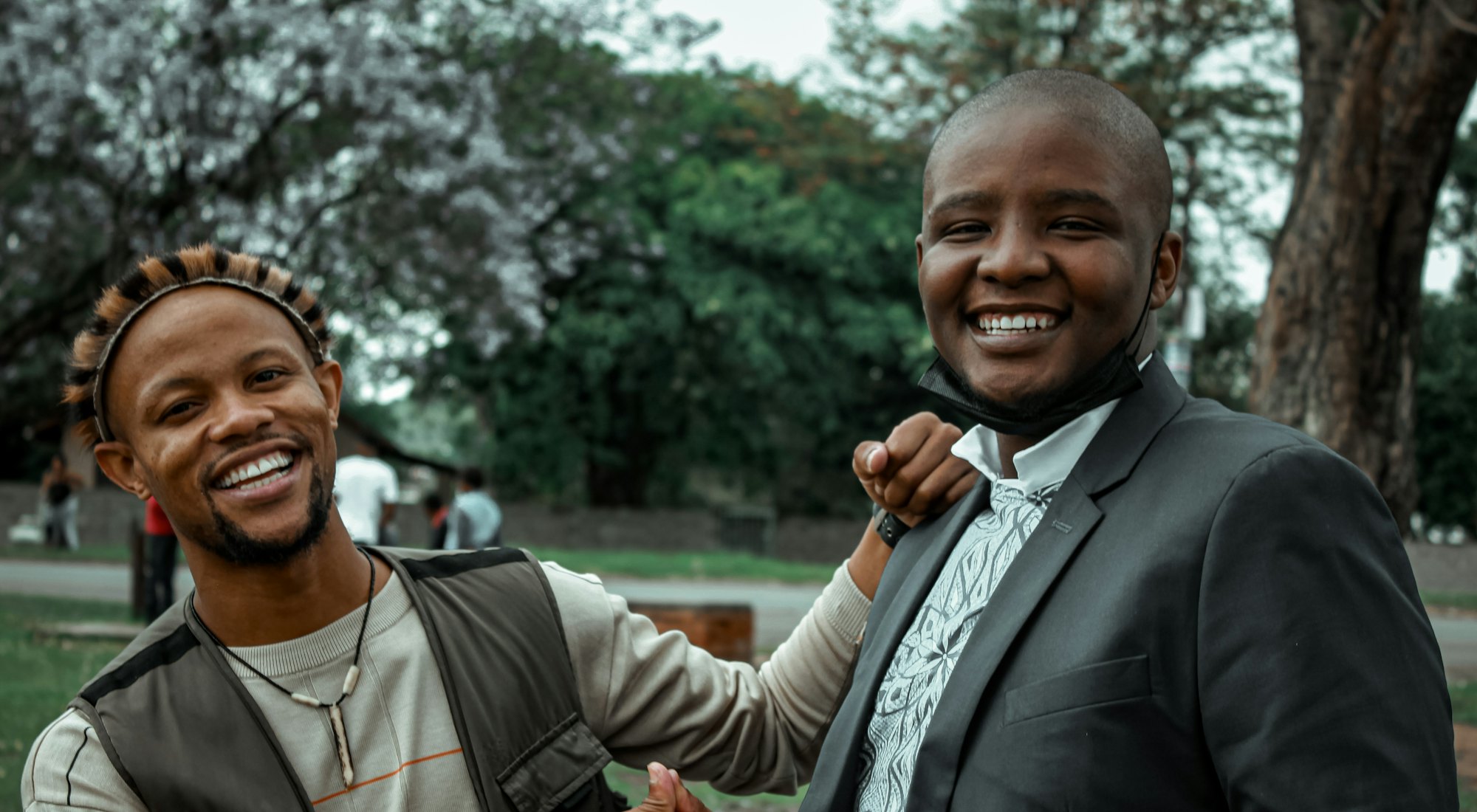 Two men smiling and shaking hands outdoors