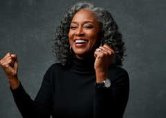 An older woman laughing with a raised fist