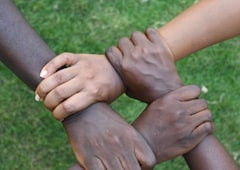 Four hands holding each other’s wrists